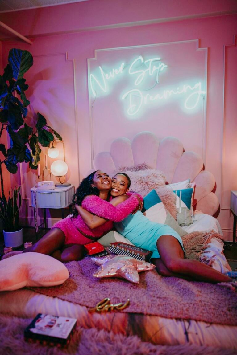 Two girls having fun in a colorful bedroom during a cozy sleepover party.